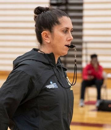 Jenna Cosgrove, basketball coach on court with whistle in her mouth